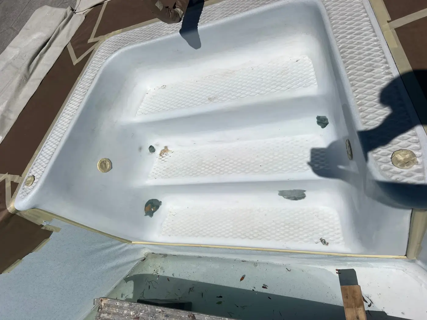 Worn fiberglass pool steps before BathMasters refinishing on the Gulf Coast